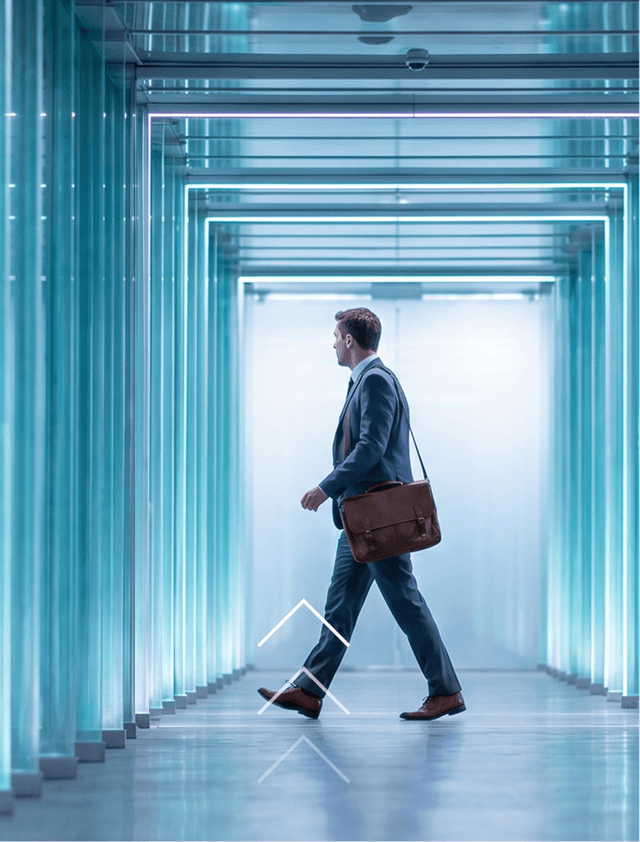 Businessman with a briefcase walking through a bright glass corridor