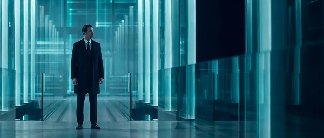 Executive standing in a glass corridor between server racks