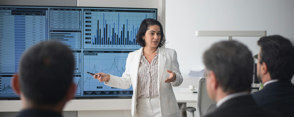 Presenter explaining financial dashboards to colleagues