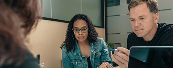 Colleagues reviewing work on a tablet