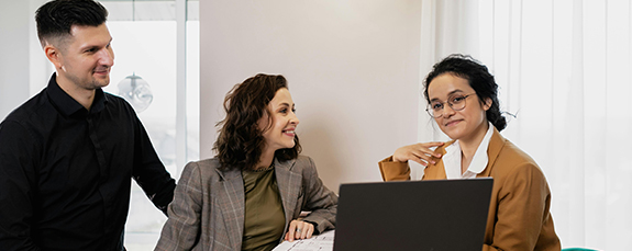 Three colleagues meeting around a laptop