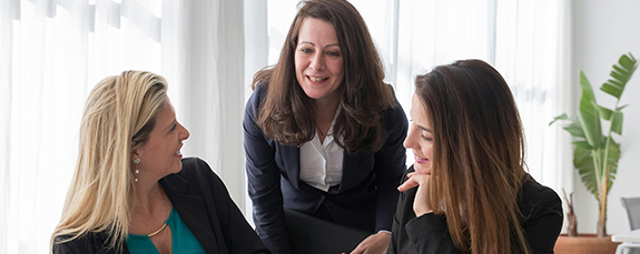 Three colleagues talking in a bright office