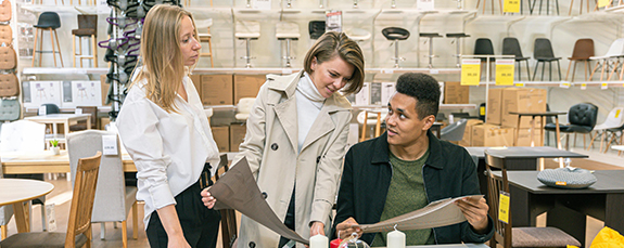 Retail staff reviewing plans in a furniture showroom