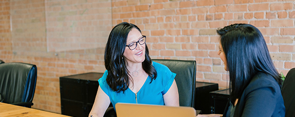 Two colleagues talking at a desk